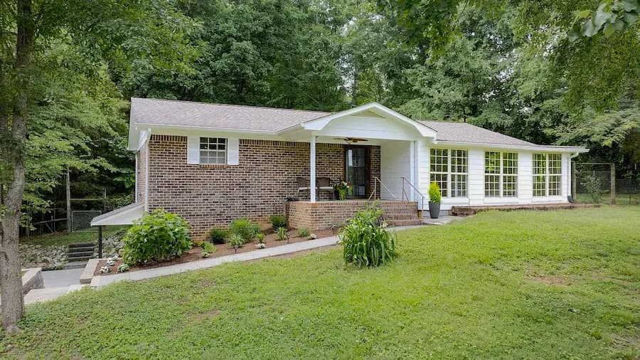 After: the same brick home with tidier planting beds, a cleared walkway, and a refreshed front porch.